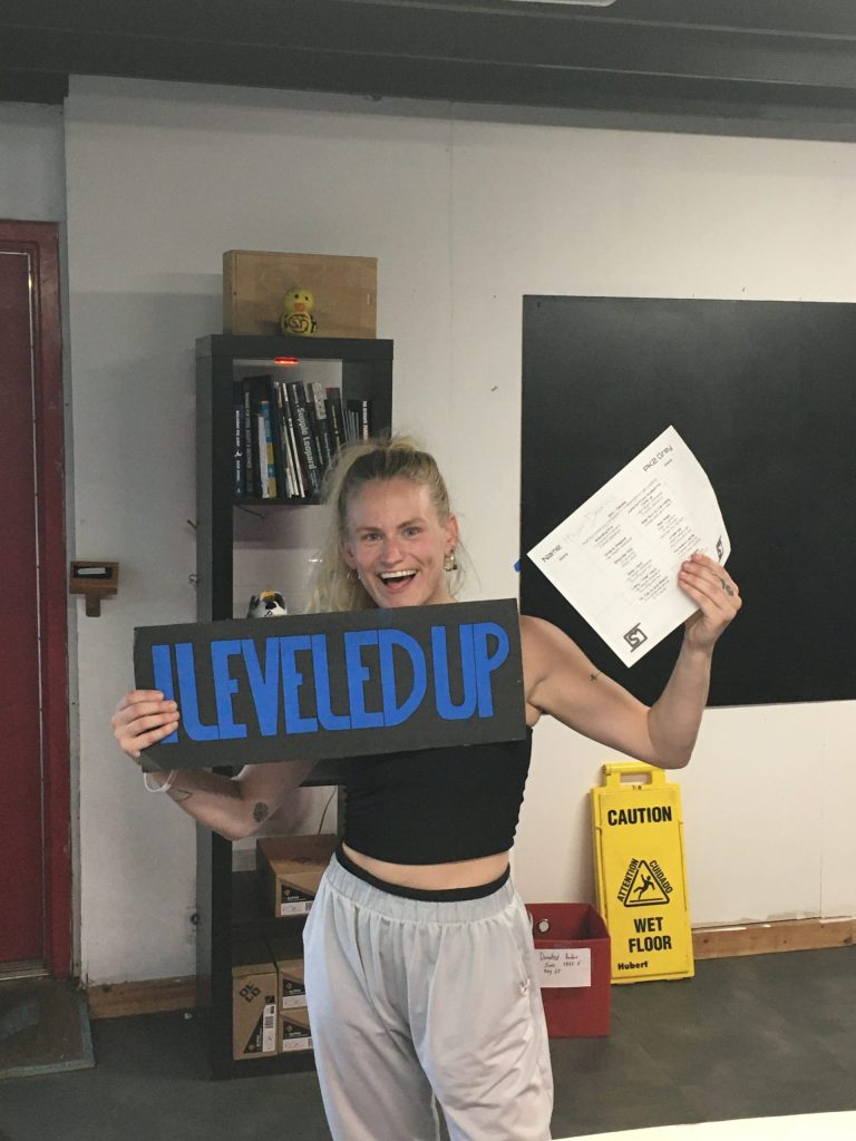 A student celebrating with a Level Up sign and skill sheet